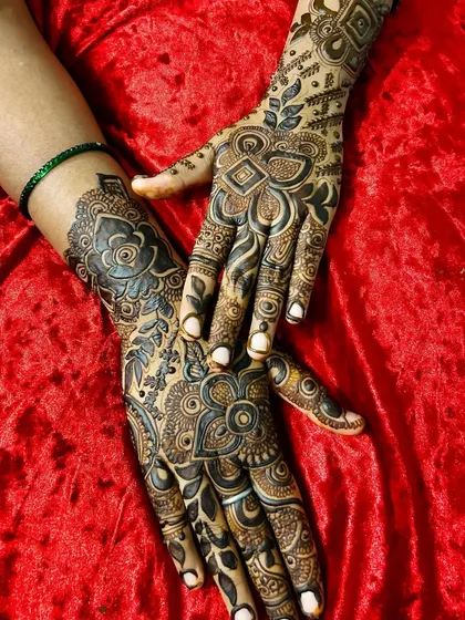 A beautifully posed shot of a dense, floral Arabic design. The dark stain and intricate patterns create a rich, luxurious look that is perfect for any celebration.