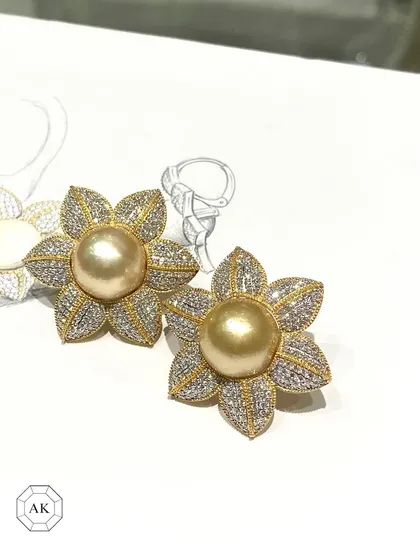 Every piece begins with a conversation, which then becomes a sketch. Here, you can see the journey of our bespoke floral earrings, from a pencil drawing to a radiant reality of golden South Sea pearls, pavé-set diamonds, and warm 18k gold. This is how your story takes shape.