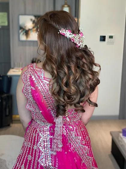 A beautiful hairstyle for a mehendi ceremony. I created a half-updo with a side braid and adorned it with a stunning fresh floral accessory.