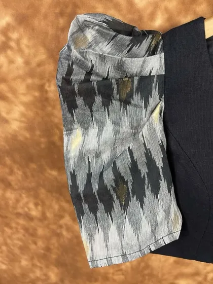 A close-up of the dramatic puff sleeve on our black blouse. The Ikat-style print in monochrome tones adds a touch of artisanal craft to a very modern silhouette.
