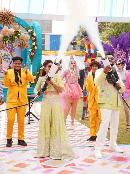 Spinning in love, dancing in joy. The bride and groom get the party started with CO2 guns, surrounded by colorful performers.