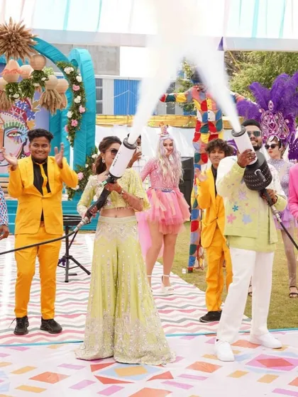 Spinning in love, dancing in joy. The bride and groom get the party started with CO2 guns, surrounded by colorful performers.