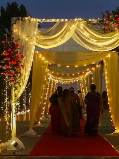 We create magical entrances that set the tone for your entire event. This beautiful walkway, draped in soft yellow fabric and illuminated by hundreds of fairy lights, provides a grand and welcoming passage for your guests.