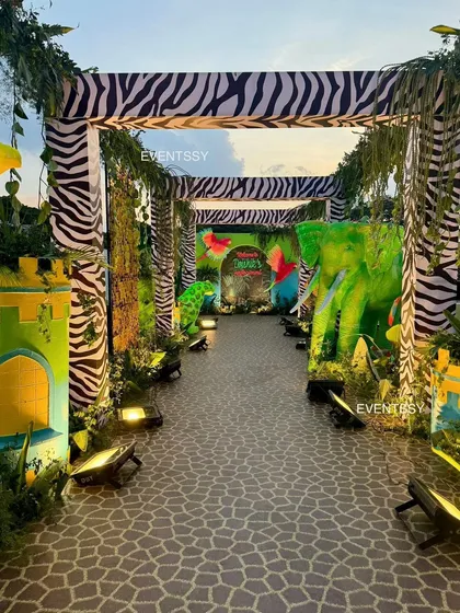 A stunning tunnel entrance with zebra-print arches and glowing animal figures guiding guests into the party.