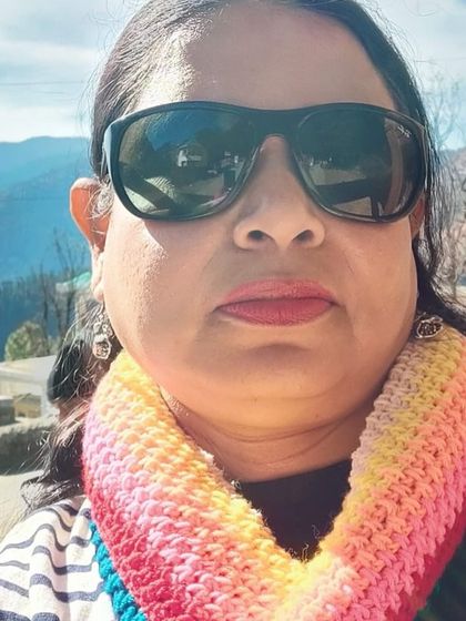 A close-up selfie from a happy customer wearing our rainbow infinity scarf. It looks so warm and cheerful.