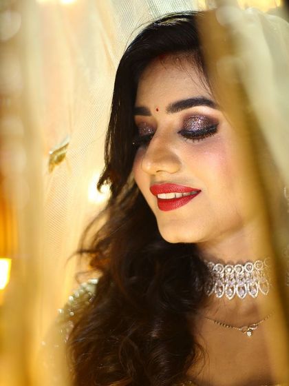 A stunning reception look. The glittery smokey eye and bold red lip are perfect for a night of celebration.