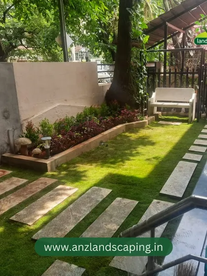 The interplay of sunlight and shadow across the newly laid lawn and pathway highlights the textures and natural beauty of the completed garden.