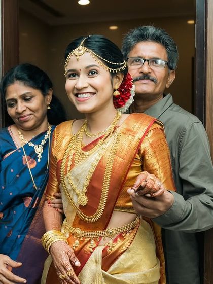 A beautiful family portrait of the bride with her proud parents, ready to make her entrance.