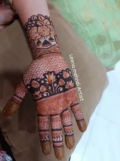 A lovely example of a developed henna stain. The design features lotuses and florals, and the rich color makes the pattern pop against the skin.