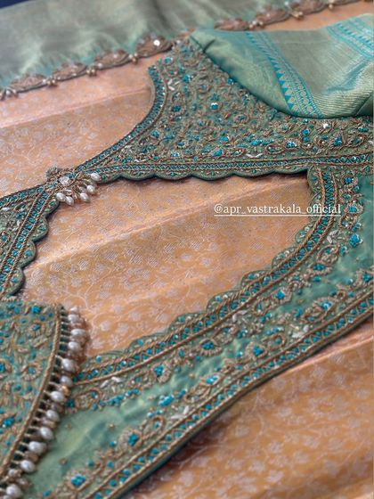 A teal blouse with a heavily embroidered back cutout.