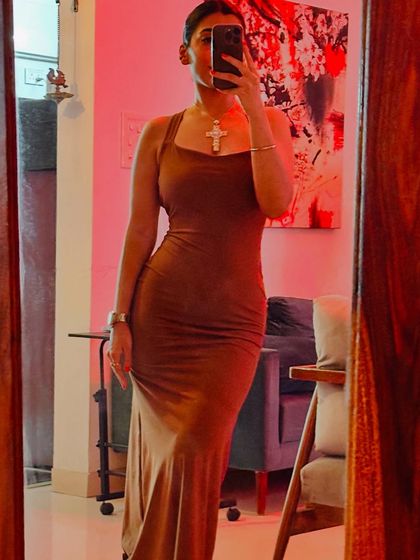 A mirror selfie in a brown bodycon dress. This image is part of a series about discovering your personal style, which could be sporty, dramatic, or classic.