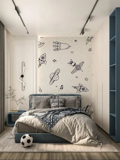 A space-themed bedroom perfect for a young explorer. The design includes a custom wallpaper with rockets and planets, a sleek blue bed, and an integrated bookshelf for storing treasures and stories.