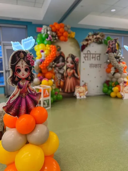 Another angle of the Seemantha Sanskar setup, highlighting a cutout of Radha. These character elements are placed throughout the venue to create an immersive and thematic experience for guests.