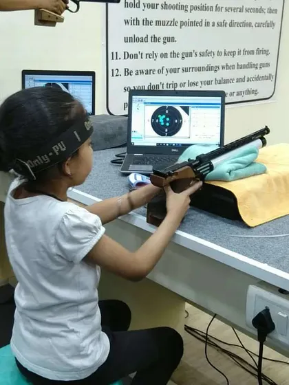 A young shooter learns the basics of aiming with an air pistol using a sitting rest for stability. We ensure that beginners build confidence with the right fundamentals.