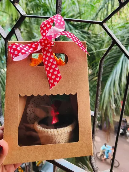 Here is the potted sunflower, all packed up and ready to be gifted. The window bag shows off the cute flower inside, and the heart-patterned ribbon adds a lovely touch.