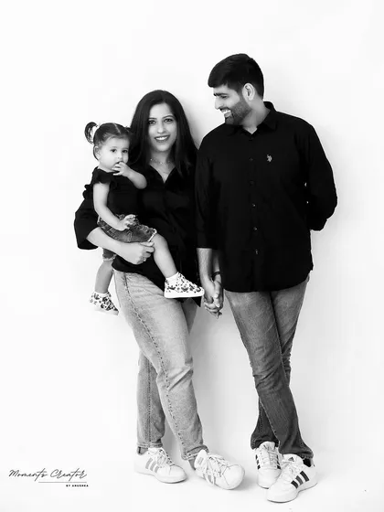 A stylish black and white family portrait. The family's coordinated casual outfits and loving interactions make for a modern and timeless image.