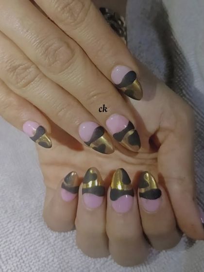 A bold design with a pink base, black abstract shapes, and a gold chrome finish.