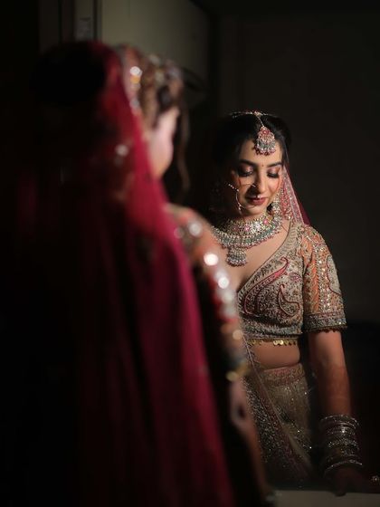 A bride looking at her reflection, adorned in a sparkling diamond-look necklace set. A quiet moment of admiration before the big celebration begins.