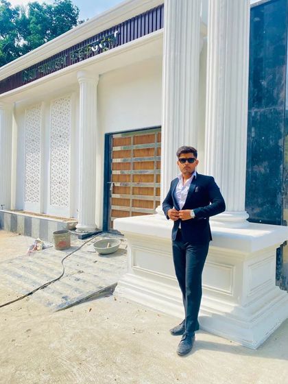 Standing in front of a building with classic architecture. My focus is on the future I am building, not the battles of the past.