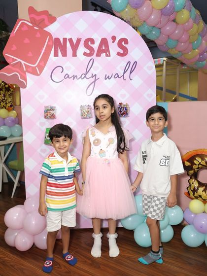 Guests at "Nysa's Candy Wall." We personalize our decor to make the birthday child the star, creating custom elements like this sweet-filled wall.