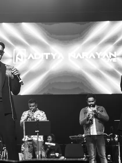 A black and white shot of a duet performance, highlighting the artists and musicians.