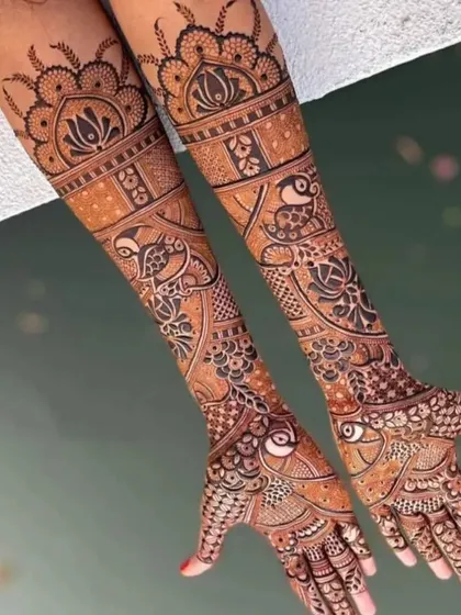 A graceful design featuring flowing vines and birds, with a large lotus motif at the top of the arms.