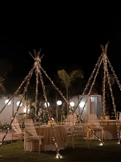 We create magical atmospheres like this "dining under the stars" experience for a milestone birthday. The fairy-lit teepee structures provide an intimate and whimsical setting for guests, perfect for garden parties and boho-themed soirées.