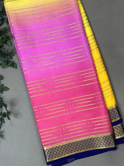 A beautiful pure Mysore silk saree with a Rangkat pattern transitioning from bright pink to sunny yellow, finished with a dark blue border.