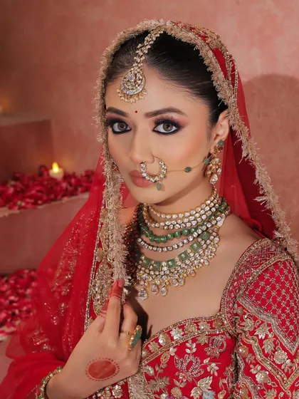 A stunning close-up of the bride, showcasing the perfect symmetry of her makeup. The kohl-rimmed eyes, defined brows, and rich lip color create a look of pure perfection.