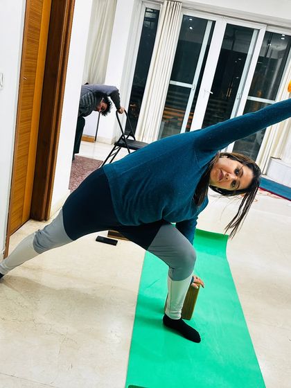 Using a wall and a block for support in Trikonasana (Triangle Pose) helps ensure proper alignment. This is part of my commitment to helping you practice safely and effectively.