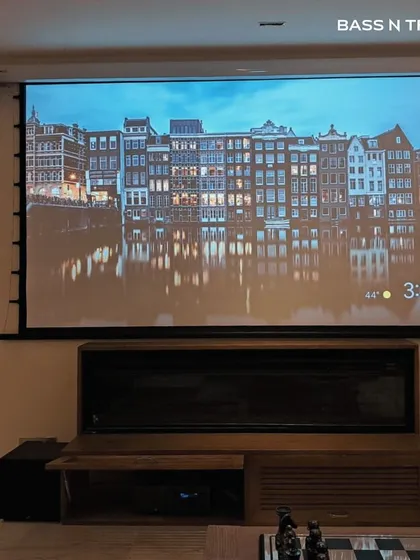 A roll-down projector screen paired with a full speaker system offers the best of both worlds. Enjoy a massive screen for movie nights and reclaim your wall when it's not in use.