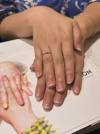The final result of a classic French manicure, looking clean and elegant on our salon's branded materials.