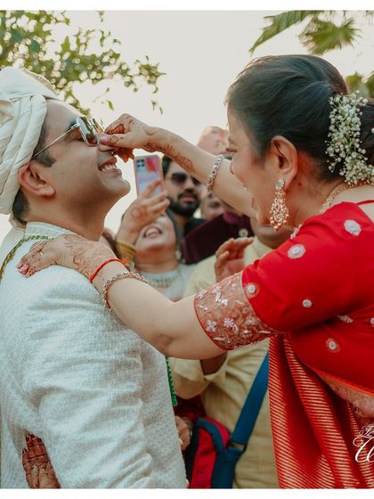 A playful moment during the groom's welcome ceremony, where the bride's family playfully pulls his nose.