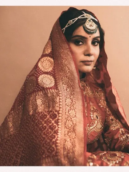Here, the focus is on the exquisite Banarasi dupatta, with its intricate gold weaving. The way it frames the bride's face adds a layer of traditional elegance and grace to the overall look.