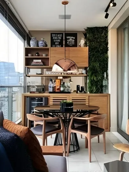 An excellent example of how a balcony can become a complete dining and entertainment area. This large space features a custom wooden bar and storage unit, a dedicated dining table, and comfortable seating. A vertical garden wall adds a touch of green, making it a perfect spot for hosting guests with a city view.