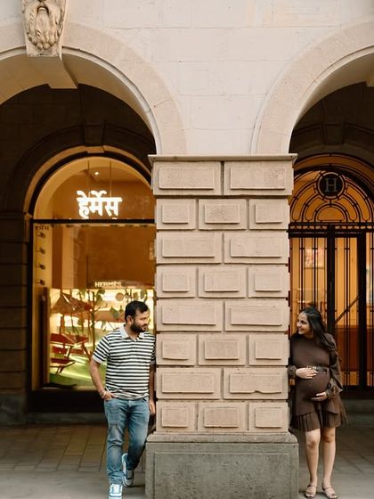 A playful moment between the couple, framed by the stunning architecture of a heritage building in Mumbai.