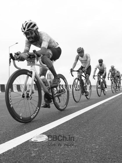 A black and white shot of the peloton, emphasizing the raw power and motion of the riders.