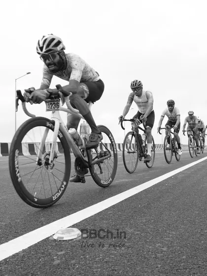 A black and white shot of the peloton, emphasizing the raw power and motion of the riders.