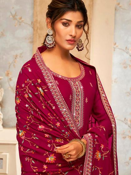 This magenta salwar kameez is vibrant and full of life. The heavy thread embroidery and mirror work make it a festive favorite.