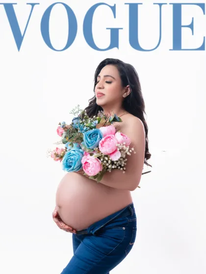 A fresh and modern "Vogue" cover concept. The mother-to-be holds a bouquet of pink and blue flowers, a playful nod to gender possibilities, creating a stylish and contemporary portrait.