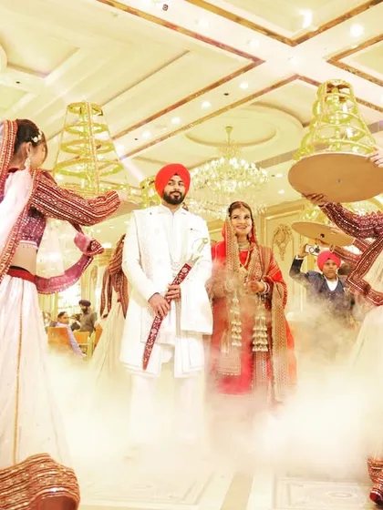 This wide-angle shot captures the scale and drama of the couple's entrance, complete with dancers and theatrical smoke. It shows the full grandeur of the wedding celebration.