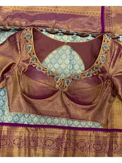 The front of the violet brocade blouse, showing its unique bustier-style cut, designed to complement the turquoise saree.