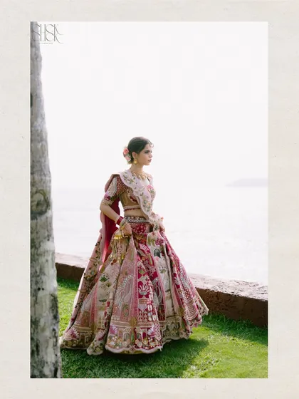 A classic bridal portrait with a scenic view. The bride stands gracefully by the Goan seaside, her intricate lehenga on full display. This is a timeless shot that captures her elegance.