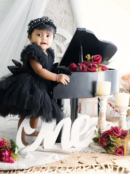 Classic and chic for her first birthday. This little girl in her black dress looks so stylish next to the miniature piano in this beautifully arranged photoshoot.