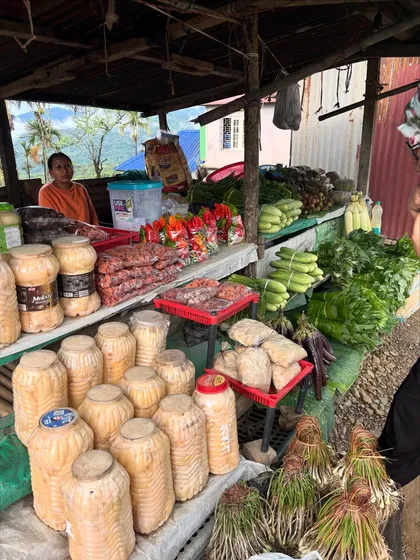 A roadside stall in Nagaland selling local produce. You can see jars of fermented bamboo shoot, fresh corn, and other vegetables, showcasing the local food culture.