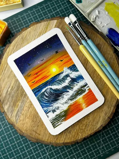 The finished sunset beach Polaroid painting, a beautiful A6 size artwork created with gouache. The waves and sun reflection are my favorite parts.