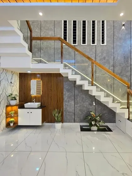 I specialize in making every corner of your home functional. Here, I designed a sleek wash basin and vanity unit under the staircase, combining modern wallpaper, wood paneling, and smart lighting to utilize the space effectively.