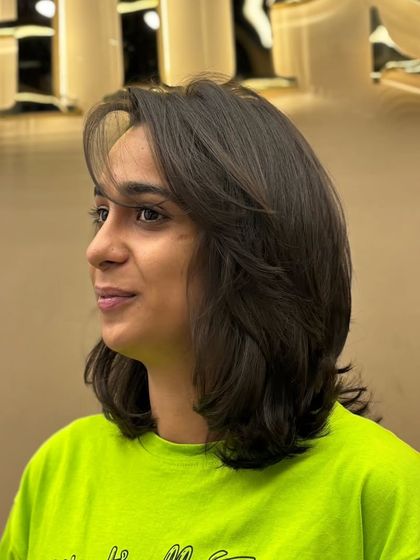 A fresh, chic, and effortlessly stylish short haircut. The layers and side-swept bangs create a modern and flattering look.