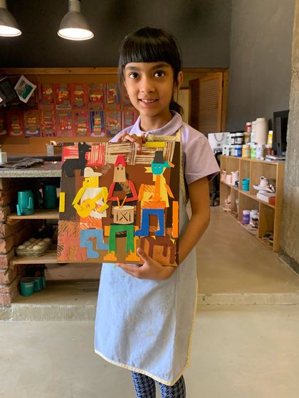A proud student with her finished Picasso-inspired collage.