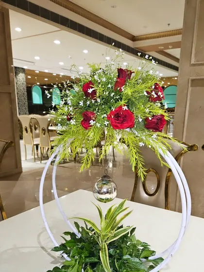 Another view of the table centerpiece, this time with red roses. These arrangements add a touch of elegance to the guest seating area.